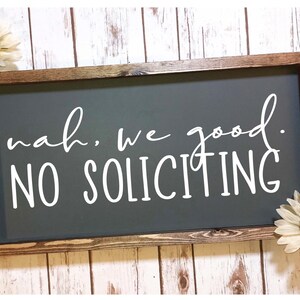 Puede incluir: Un letrero de madera con fondo gris y texto blanco que dice "nah. we good. NO SOLICITING". El letrero está enmarcado en un marco de madera marrón oscuro.