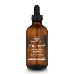 Op de afbeelding: Een bruine glazen fles met een druppelaar gevuld met zoete amandelolie. Het etiket vermeldt "Nature's Leaf Sweet Almond Prunis dulcis Organic Moisturizing Oil Huile Hydratante U.S.D.A. Certified Organic 118 ml / 4 fl oz."