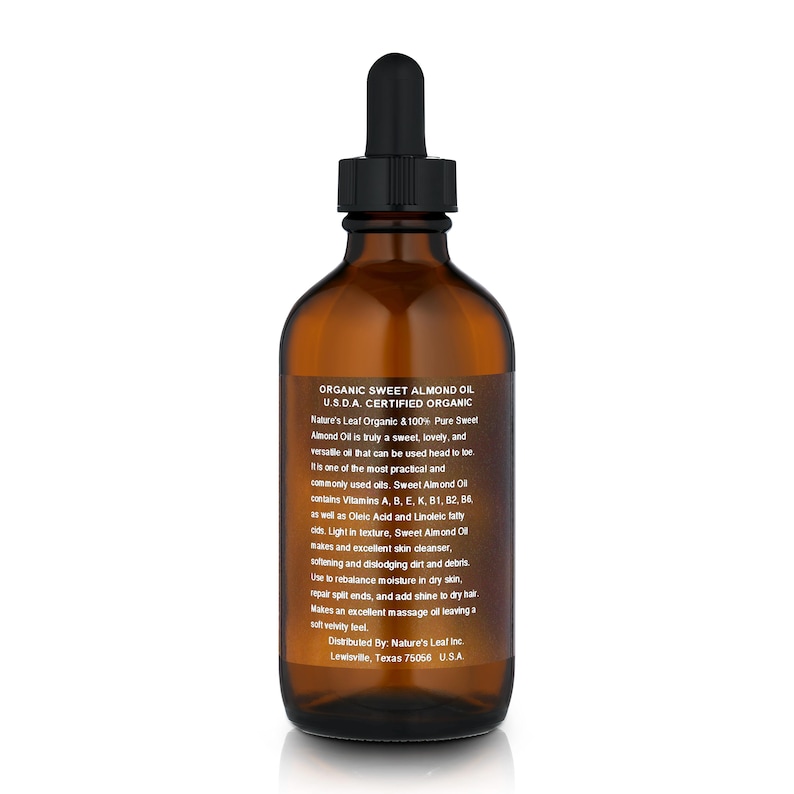 Op de afbeelding: Een bruine glazen fles met USDA-gecertificeerde biologische zoete amandel olie. De fles heeft een zwarte druppelaar en een wit etiket met zwarte tekst. Het etiket vermeldt "Organic Sweet Almond Oil, USDA Certified Organic, Nature's Leaf Organic & 100% Pure Sweet Almond Oil is truly a sweet, lovely, and versatile oil that can be used head to toe. It is one of the most practical and commonly used oils. Sweet Almond Oil contains Vitamins A, B, E, K, B1, B2, B6 as well as Oleic Acid and Linoleic fatty acids. Light in texture, Sweet Almond Oil makes an excellent skin cleanser, softening and dislodging dirt and debris. Use to rebalance moisture in dry skin, repair split ends, and add shine to dry hair. Makes an excellent massage oil leaving a soft velvety feel. Distributed By: Nature's Leaf Inc. Lewisville, Texas 75056, USA."