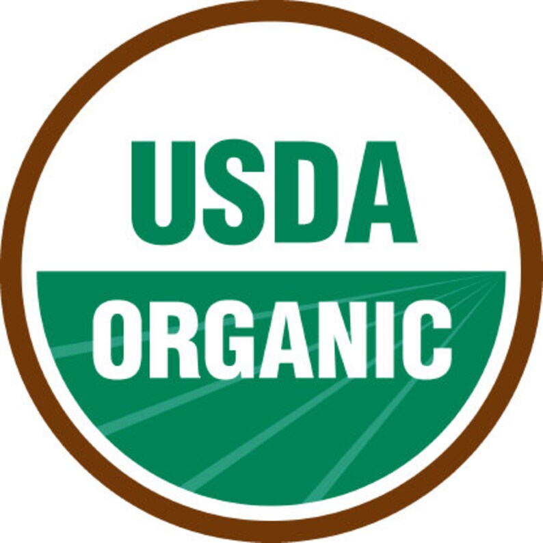 Op de afbeelding: Een bruine cirkel met een witte achtergrond en groene tekst. De tekst luidt "USDA ORGANIC".