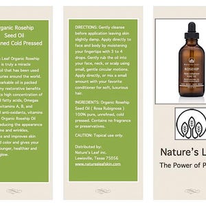 May include: A green and white label with the text "Nature's Leaf Organic Rosehip Seed Oil" and "The Power of Plants". A clear glass bottle with a brown cap and a green label with the text "Rosehip" is shown in the image. The bottle is sitting on a white surface.