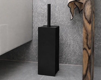 Puede incluir: Un juego de escobilla para inodoro en color negro mate que presenta una base rectangular alta y un mango cilíndrico a juego. El diseño es elegante y de color uniforme, proporcionando una estética sólida y oscura para el baño.