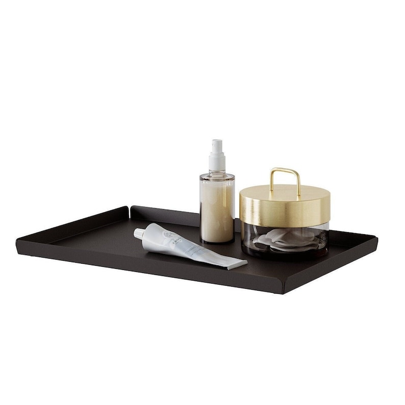 May include: A black metal tray with a gold lidded jar, a white tube of cream, and a clear bottle with a white spray top.
