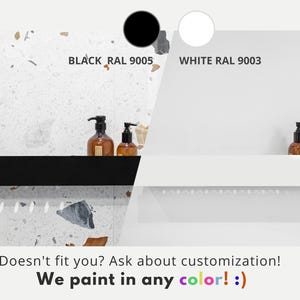 May include: Two bathroom shelves, one black and one white, with a terrazzo tile backsplash. The shelves are empty except for two bottles of liquid soap on the black shelf.