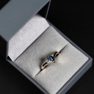 14K yellow gold alexandrite chevron ring with accent diamond in a jewelry box