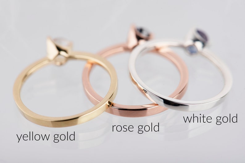 May include: Three simple gold rings, one in yellow gold, one in rose gold, and one in white gold.
