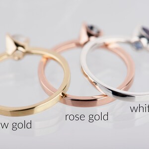 May include: Three simple gold rings, one in yellow gold, one in rose gold, and one in white gold.