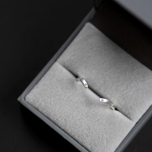 14K white gold two little diamonds open curved wedding band in a jewelry box