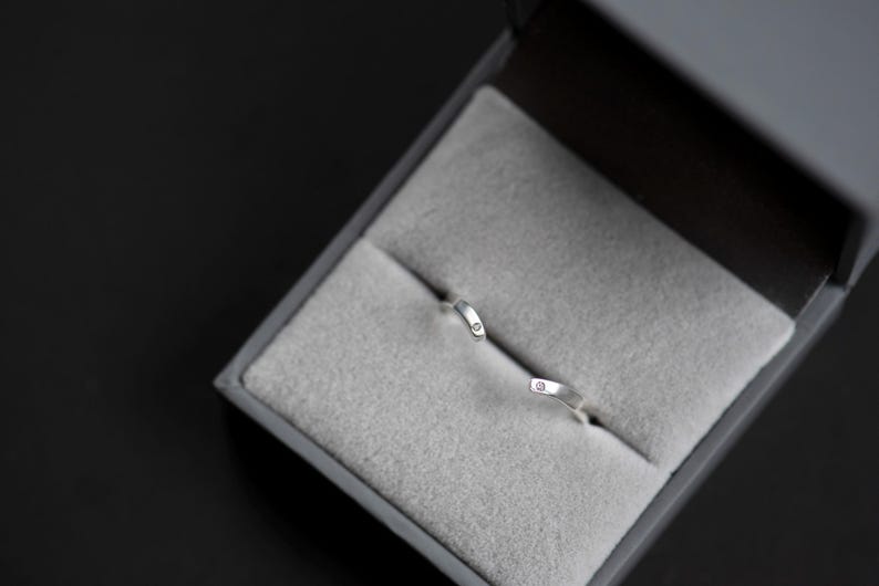 14K white gold two little diamonds open curved wedding band in a jewelry box