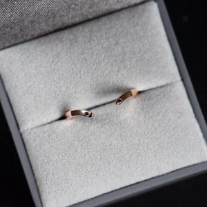 14K rose gold two little black diamonds open curved wedding band in a jewelry box