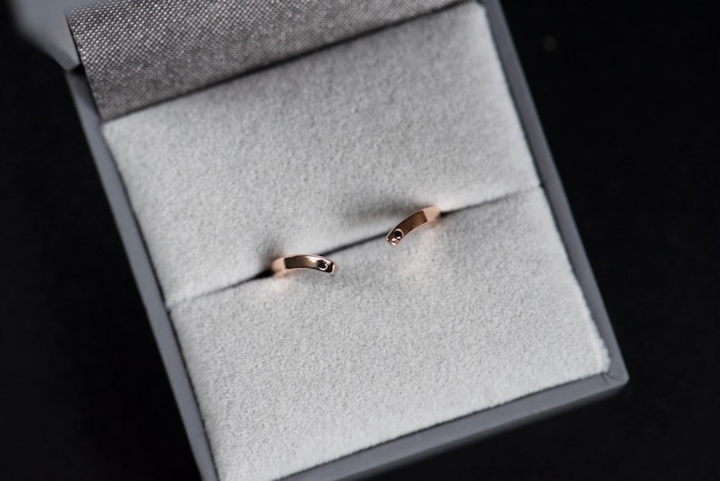 14K rose gold two little black diamonds open curved wedding band in a jewelry box