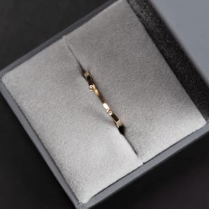 14K yellow gold two little diamonds open curved wedding band in a jewelry box