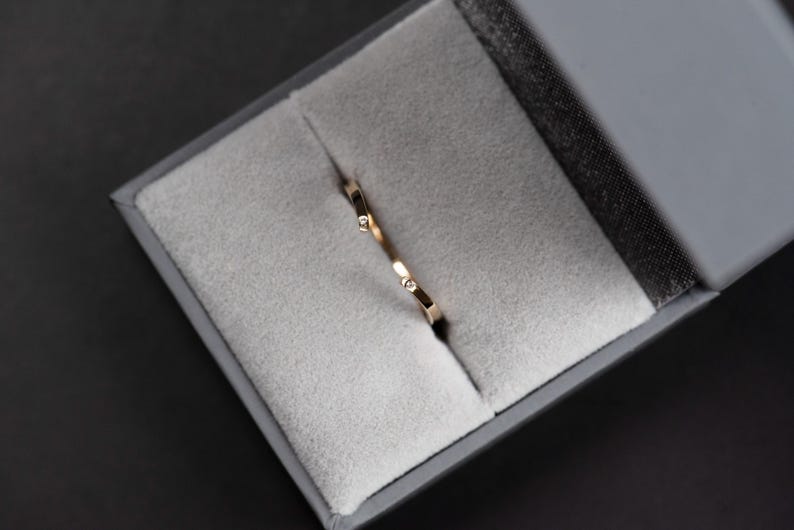 14K yellow gold two little diamonds open curved wedding band in a jewelry box