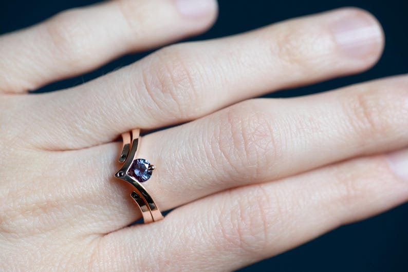 14K rose gold two little black diamonds open curved wedding band and 14K rose gold alexandrite and black diamond chevron ring on finger