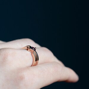 14K rose gold two little black diamonds open curved wedding band and 14K rose gold alexandrite and black diamond chevron ring on finger