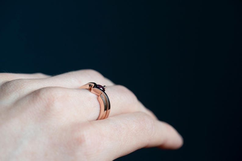 14K rose gold two little black diamonds open curved wedding band and 14K rose gold alexandrite and black diamond chevron ring on finger