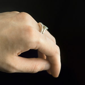 Sterling silver cubic zirconia enhancer chevron band and sterling silver moonstone ring on hand. Moonstone and CZ stacking rings