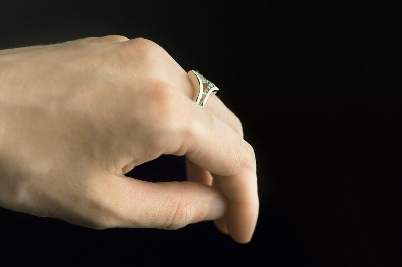 Sterling silver cubic zirconia enhancer chevron band and sterling silver moonstone ring on hand. Moonstone and CZ stacking rings