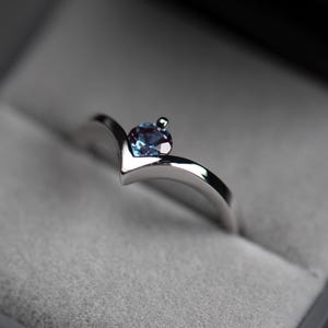 14K white gold alexandrite chevron ring with accent diamond in a jewelry box