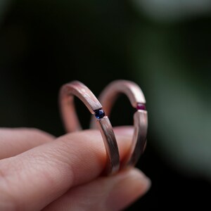 Two mokume gane sterling silver and copper tension engagement rings - one with natural blue sapphire and one with natural deep pink ruby