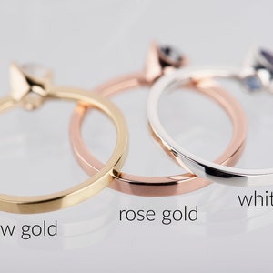 May include: Three simple gold rings, one in yellow gold, one in rose gold, and one in white gold.