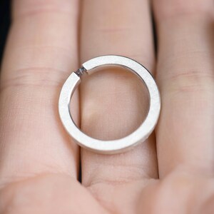 Sterling silver lab created alexandrite tension promise unisex ring on hand