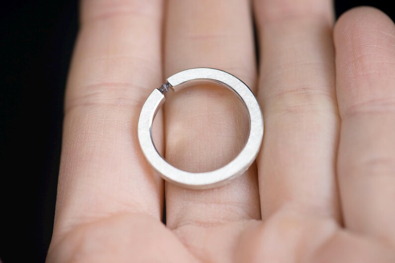 Sterling silver lab created alexandrite tension promise unisex ring on hand