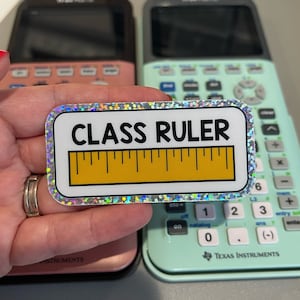 May include: A holographic sticker with the text "CLASS RULER" and a yellow ruler graphic.