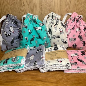 Puede incluir: Conjunto de cuatro toallitas faciales reutilizables en bolsas de cordón. Cada bolsa presenta un diseño de estampado de gato diferente: gris, verde azulado, crema y rosa. Las toallitas están hechas de un tejido suave y absorbente y son perfectas para quitar el maquillaje o limpiar la cara.