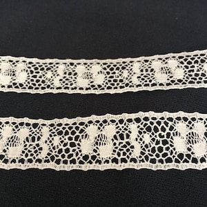 Pode incluir: Renda branca com um delicado padrão floral. A renda tem aproximadamente 2,5 cm de largura.