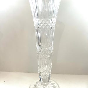 May include: A clear glass vase with a diamond pattern and a flared base.