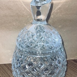 Könnte beinhalten: Eine durchsichtige Glasdose mit einem Diamantenmuster. Die Dose hat einen Deckel mit einem Knopf oben.