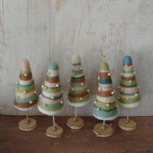 Five small Christmas trees made from needle felting over styrofoam, on wood bases. Made with pastel  blues, greens and brown wool.