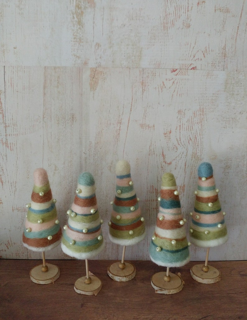 Five small Christmas trees made from needle felting over styrofoam, on wood bases. Made with pastel  blues, greens and brown wool.