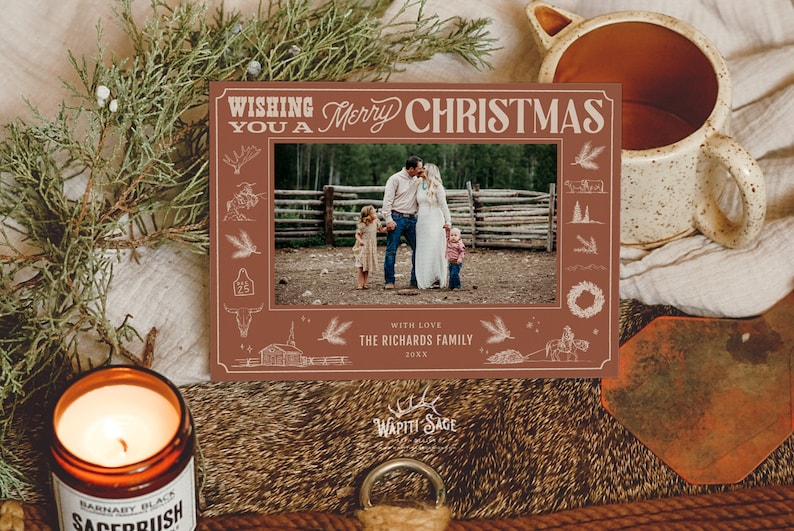 K&ouml;nnte beinhalten: Eine rote Weihnachtskarte mit wei&szlig;em Rand, auf der eine vierk&ouml;pfige Familie vor einem Holzzaun steht. Die Karte hat ein rustikales Design mit Illustrationen einer H&uuml;tte, eines Pferdes und eines Kranzes. Der Text auf der Karte lautet "Wishing you a Merry Christmas" und "With love, The Richards Family 20XX".