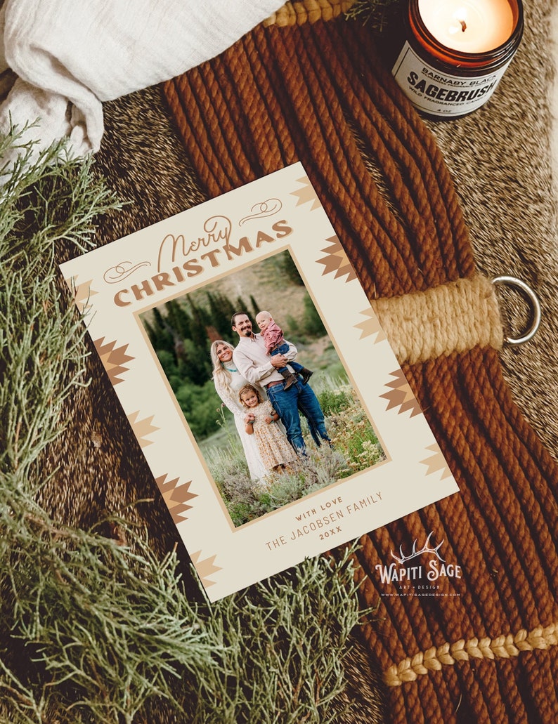 May include: A Christmas card with a brown and beige geometric pattern. The card features a photo of a family of three standing in a field. The text "Merry Christmas" is written in a stylized font. The card also includes the text "With Love, The Jacobsen Family, 20XX".