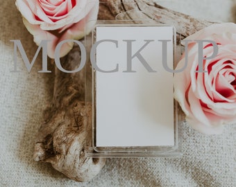 May include: A white blank label in a clear plastic packaging with a hanging loop. The label is surrounded by two pink roses on a beige fabric background.