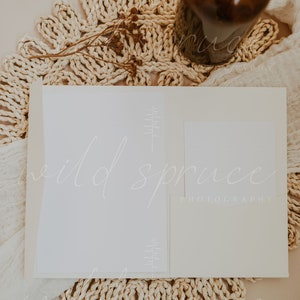 Puede incluir: Una tarjeta blanca con el texto "wild spruce photography" en ella. La tarjeta est&aacute; sobre una estera tejida con una botella de vidrio marr&oacute;n y flores secas.