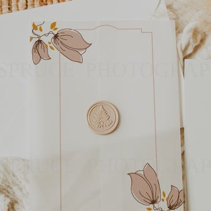 May include: A white card with a decorative border and floral illustrations. A wax seal with a tree design is in the center of the card.