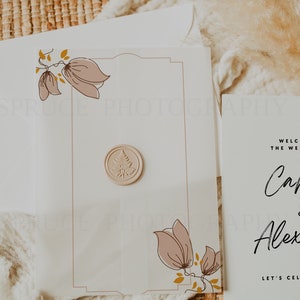 May include: A white wedding invitation with a floral design and a wax seal. The invitation reads "Welcome to the wedding of...  Let's Celebrate!"