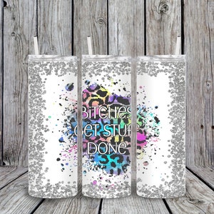 Puede incluir: Tres vasos transparentes con purpurina plateada y fondo blanco. Los vasos tienen un diseño de estampado de leopardo colorido y un texto en blanco y negro que dice "Bitches Get Stuff Done".