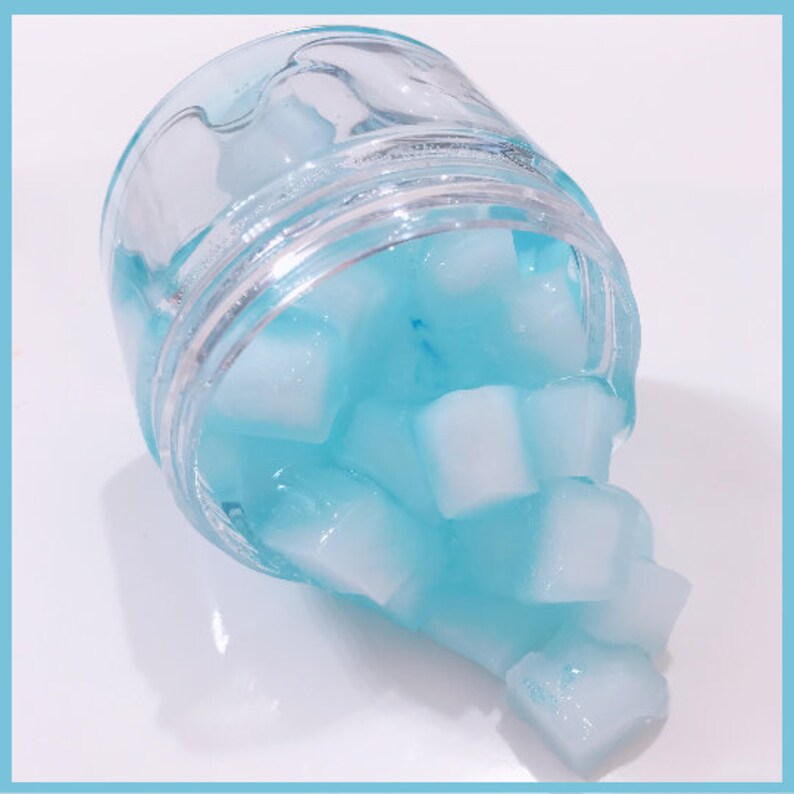 May include: A glass jar filled with translucent blue and white jelly cubes. The jar is tilted, and the cubes are spilling out.