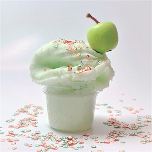 May include: Green slime with apple-shaped sprinkles in a clear plastic container topped with a green apple.