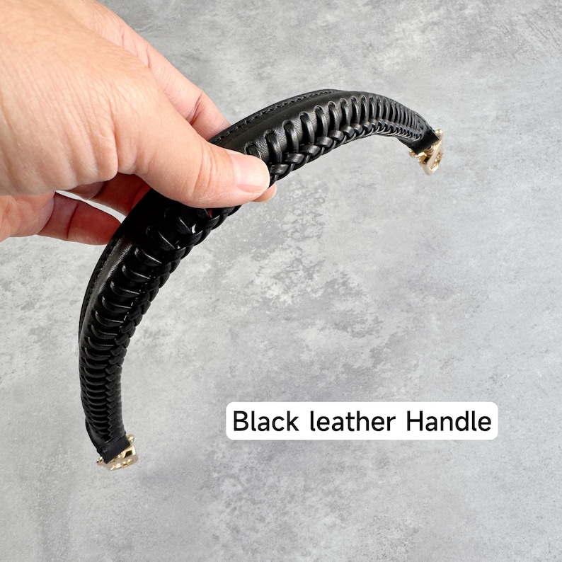 May include: Black leather handle with a braided design. The handle has gold-coloured metal accents on each end. The text "Black leather Handle" is displayed in a white rectangle.