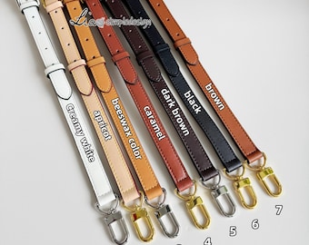 May include: Seven different colored leather straps with gold hardware. The straps are labeled with their colors: creamy white, apricot, beeswax color, caramel, dark brown, black, and brown.