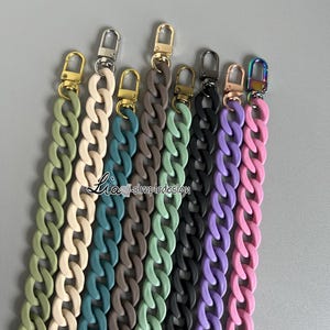 May include: Seven colorful chain straps with silver, gold, and black clasps. The chains are made of a thick, rubber-like material and come in colors like beige, teal, dark green, light green, black, purple, and pink.