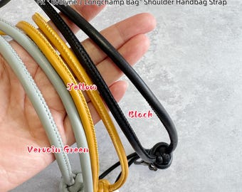 May include: Three tubular shoulder handbag straps in black, yellow, and vervain green. Each strap features a knotted end and is labeled as a Fit Evelyne / Longchamp Bag Shoulder Handbag Strap. The straps are smooth and rounded in construction.