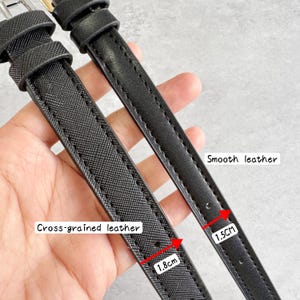 May include: Two black watch straps featuring different textures. One strap has a cross-grained leather finish measuring 1.8 cm in width, while the other strap has a smooth leather finish measuring 1.5 cm in width. Both straps include metal buckles.