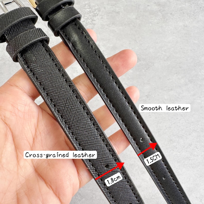May include: Two black watch straps featuring different textures. One strap has a cross-grained leather finish measuring 1.8 cm in width, while the other strap has a smooth leather finish measuring 1.5 cm in width. Both straps include metal buckles.