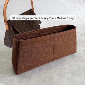 May include: A brown felt insert organizer for a handbag, featuring multiple interior compartments and a structured rectangular shape. The text "Felt Insert Organizer for Looping Mini / Medium / Large" is visible above a brown patterned handbag.
